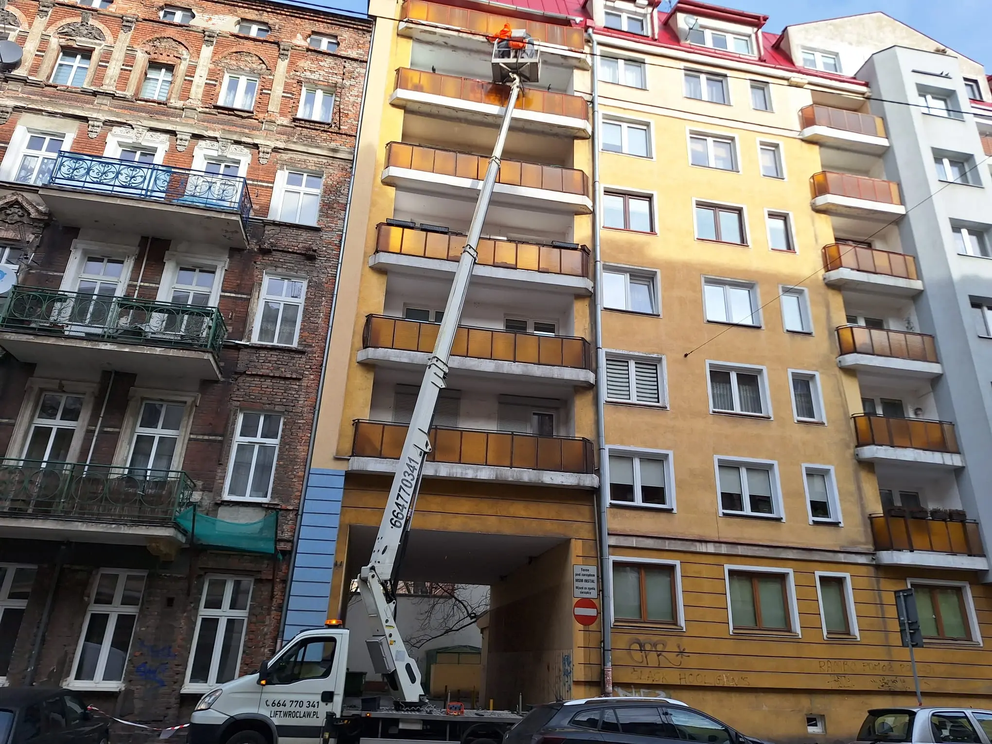 Prace przy elewacji budynku z użyciem zwyżki we Wrocławiu